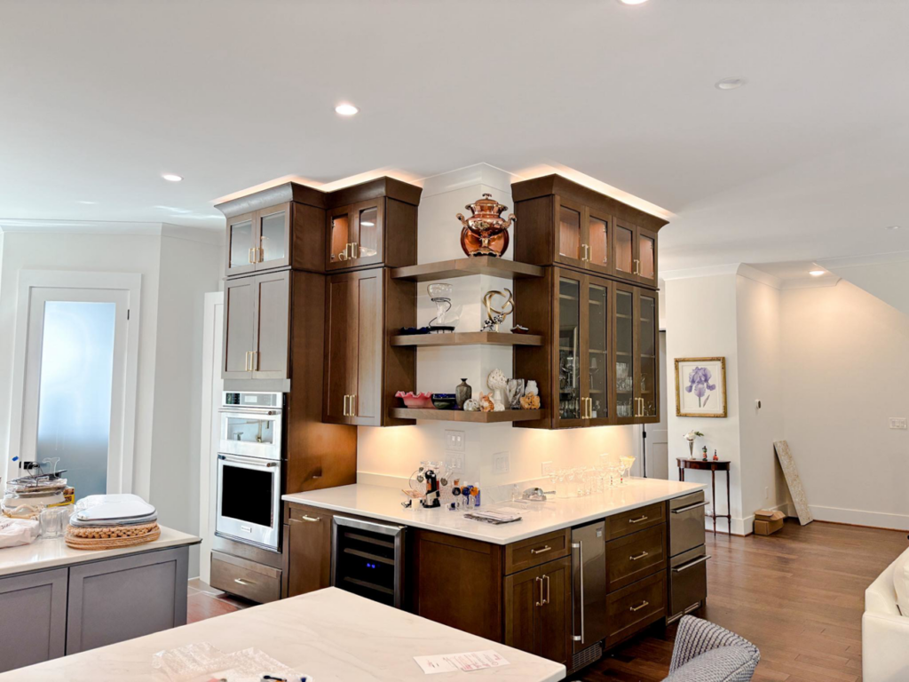 A modern kitchen renovation featuring custom dark wood cabinets and built-in appliances by Welcome Home Building Services in Winston-Salem, NC.