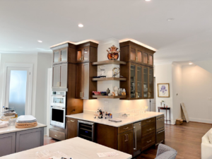 A modern kitchen renovation featuring custom dark wood cabinets and built-in appliances by Welcome Home Building Services in Winston-Salem, NC.