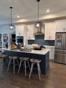 A modern kitchen renovation featuring a large island, pendant lights, and a diamond-patterned backsplash by Tile Jawn in Philadelphia, PA.