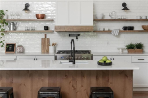 A beautifully renovated modern kitchen with white subway tile, open shelving, and a large island by Dogwood Renovation & Design, LLC in Kansas City, MO.