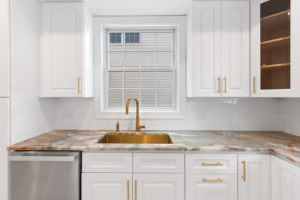 A newly renovated modern kitchen with white cabinets and a unique countertop by EK Construction, LLC in Philadelphia, PA