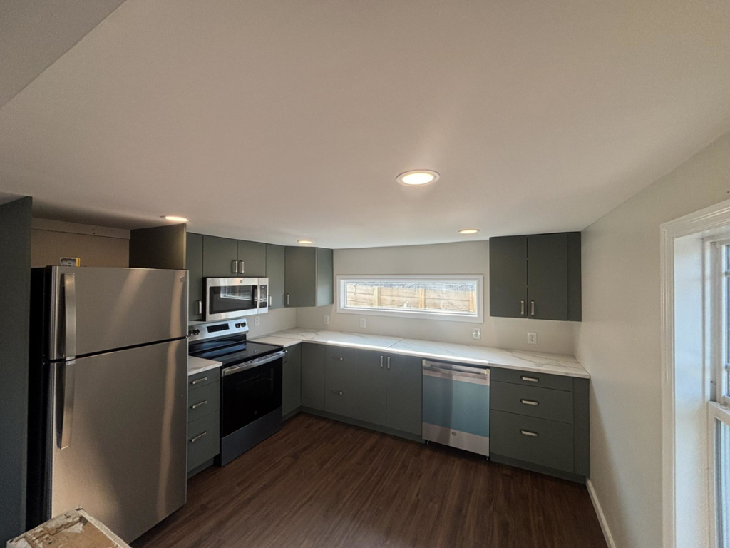 A modern kitchen with new green cabinets and stainless steel appliances installed by Fox Renovations in Knoxville, TN