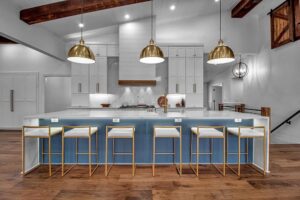A stunning modern kitchen renovation featuring a large island, gold pendant lights, and exposed beams, completed by Bob Build's WNY in Buffalo, NY.