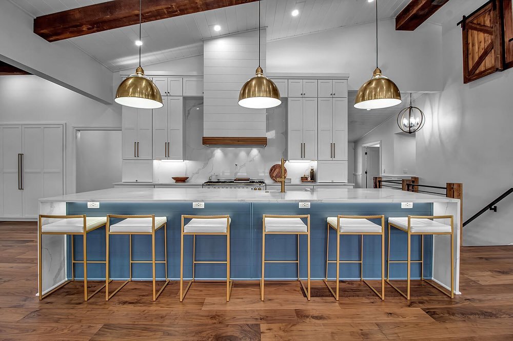 A stunning modern kitchen renovation featuring a large island, gold pendant lights, and exposed beams, completed by Bob Build's WNY in Buffalo, NY.