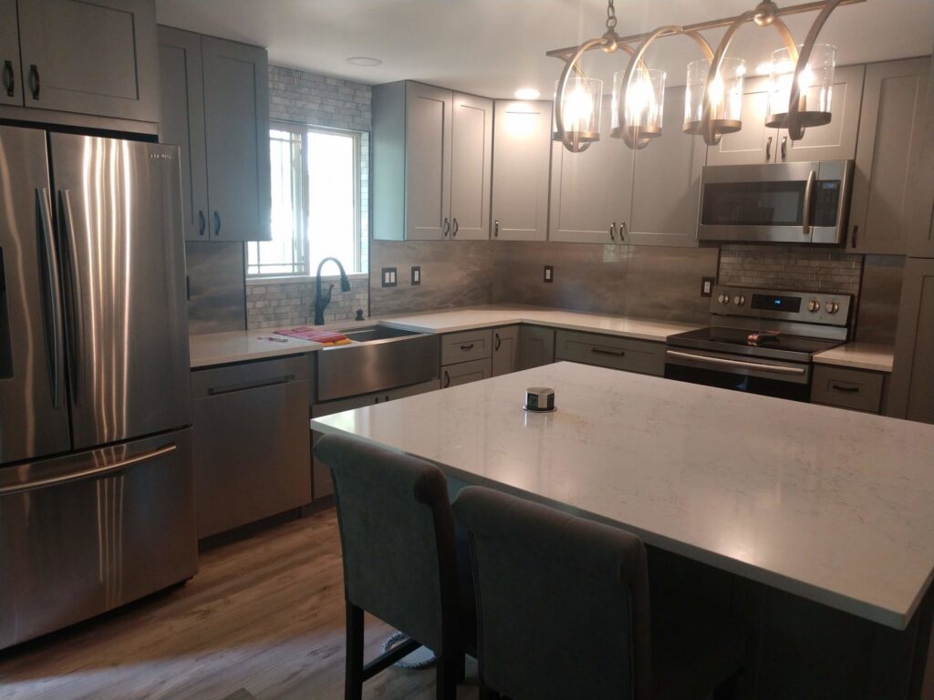 A modern kitchen renovation with gray cabinets and stainless steel appliances by Indy Renovation in Indianapolis, IN.