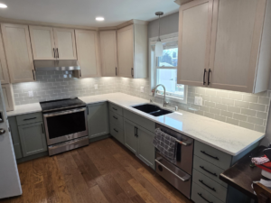 A modern kitchen renovation featuring new cabinets, backsplash, and hardwood floors by L.A. Floors in Madison, WI.