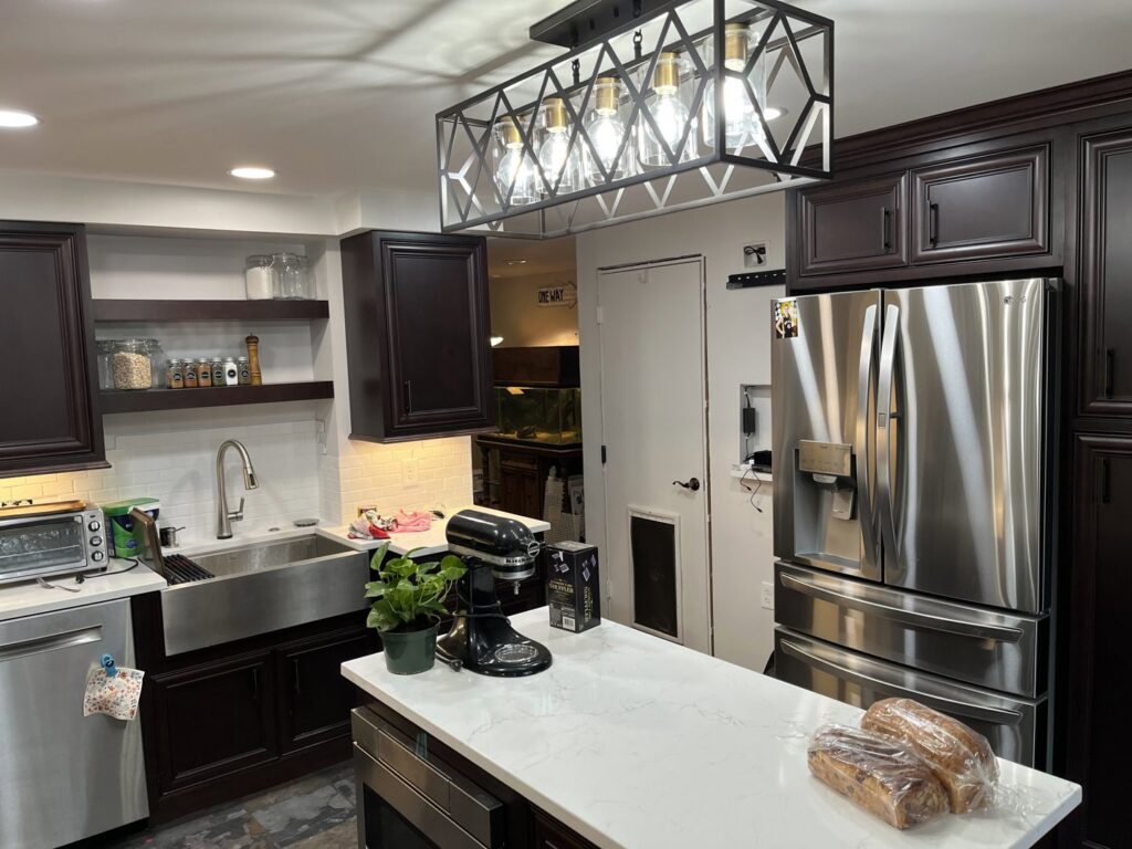 A modern kitchen renovation featuring dark cabinets, a large island, and stainless steel appliances by 3Rivers General Contracting in Pittsburgh, PA.