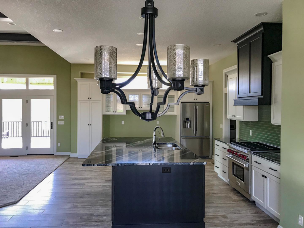 A modern kitchen renovation featuring a large island, new cabinets, and appliances by Grabill Painting and Drywall in Fort Wayne, IN.