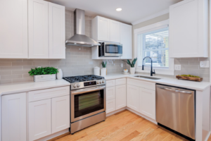 A modern kitchen renovation featuring white cabinets, stainless steel appliances, and a subway tile backsplash by Lehr Design Build LLC in Salisbury, MD.