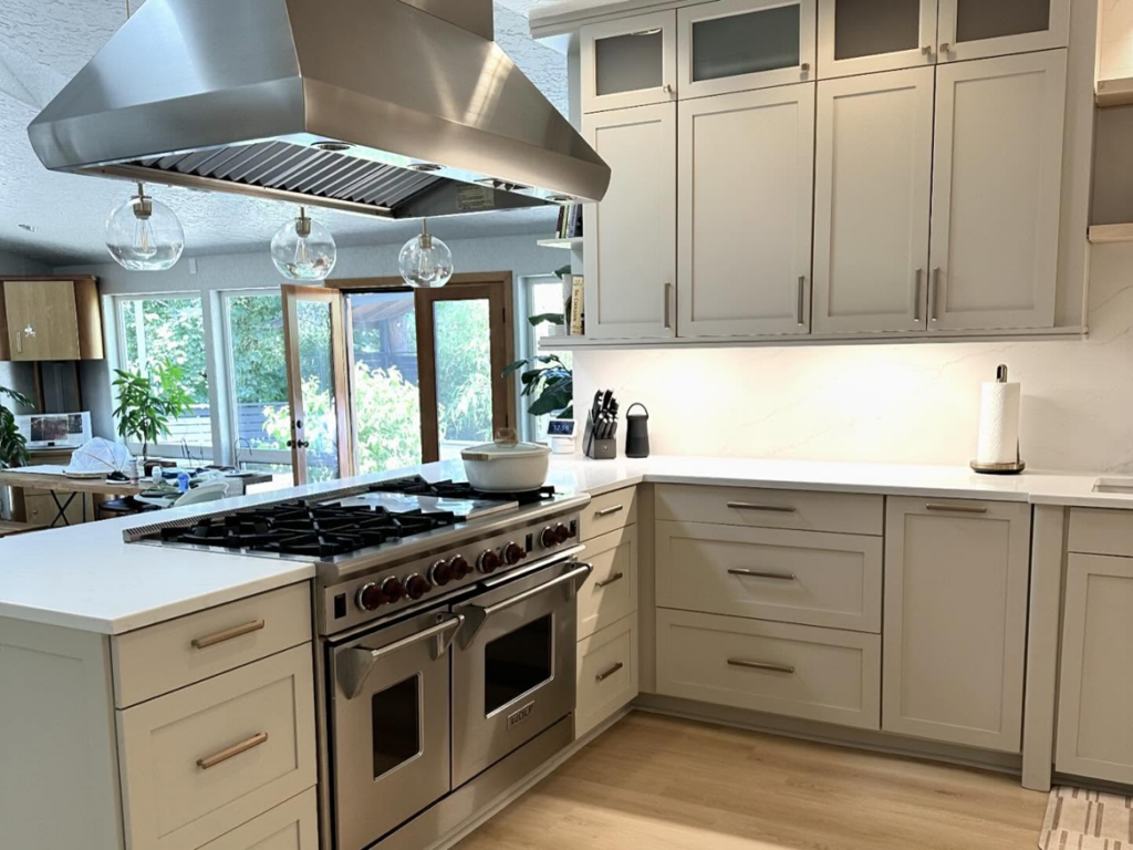 Modern kitchen renovation featuring light grey cabinets and new countertops by Cabinet Refinishing Northwest in Beaverton, OR.