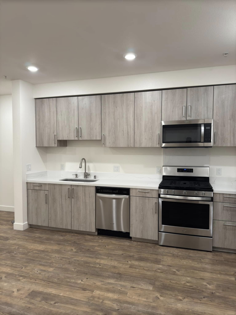 A modern kitchen renovation with new gray cabinets, white countertops, and stainless steel appliances by Alitos Handyman in San Jose, CA.