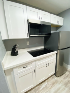 A modern kitchen renovation with white cabinets and stainless steel appliances by Property Solutions Network, Llc in Hialeah, FL