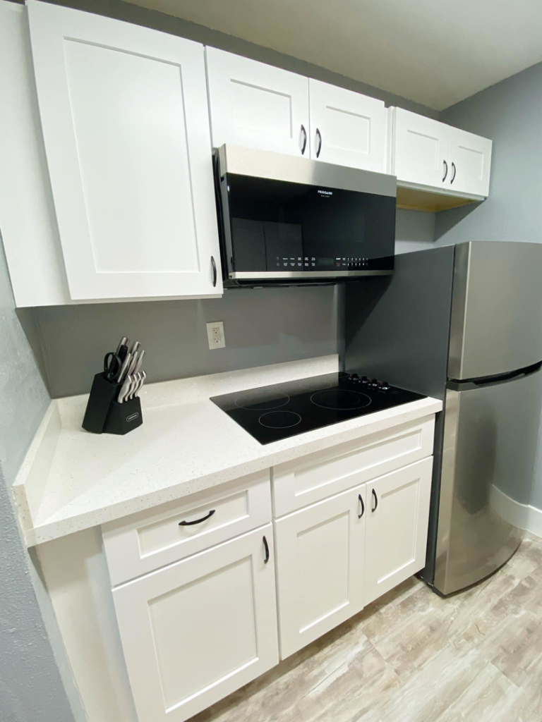 A modern kitchen renovation with white cabinets and stainless steel appliances by Property Solutions Network, Llc in Hialeah, FL