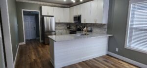A complete modern kitchen renovation with white cabinets and new appliances by Rapid Repairs and Renovations in Knoxville, TN.