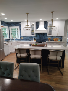 A beautifully renovated modern kitchen with blue tile backsplash and white cabinets by Rapid Response Crew in Charlotte, NC.