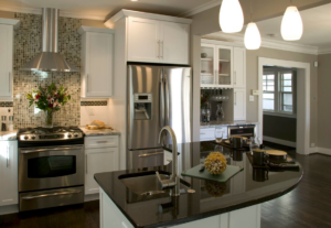 A modern kitchen renovation featuring white cabinets and stainless steel appliances by RARE Construction, Inc. in Kansas City, MO.