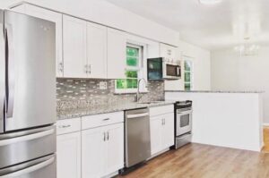 A modern kitchen renovation featuring white cabinets and stainless steel appliances by Creative Touch Renovations LLC in Harrisburg, PA.