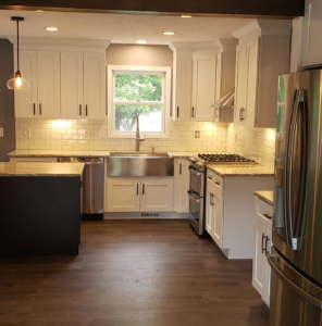 A newly renovated modern kitchen featuring white cabinets and subway tile backsplash by V.F Contracting L.L.C in Parma, OH.