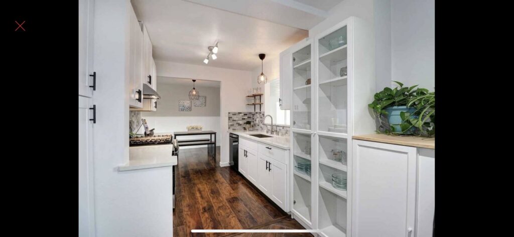 A modern kitchen renovation showcasing white cabinets, dark wood flooring, and new appliances by The Sioux Falls Handyman in Sioux Falls, SD.