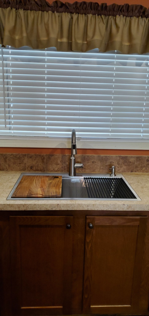 A newly installed modern kitchen sink with a pull-down faucet by Walnut Bridge Construction in Knoxville, TN