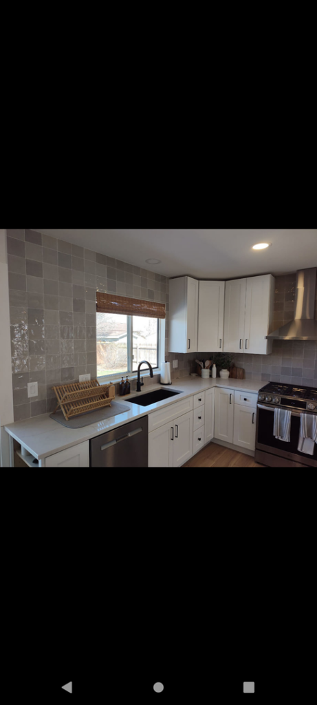 A modern kitchen sink area with white cabinets and light gray backsplash, installed by Layvic Construction LLC in Downtown Denver, CO