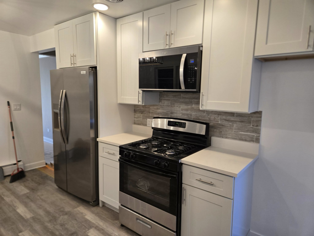 A modern kitchen featuring new stainless steel appliances and a stylish backsplash by Specialized Building Services Inc. in Chicago, IL.