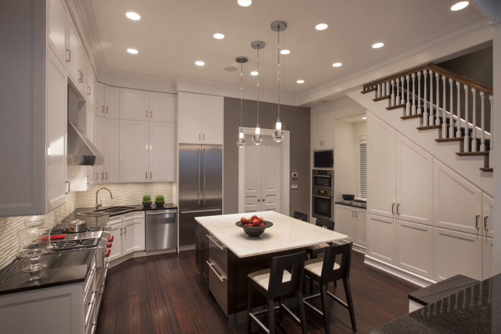 A modern kitchen and adjacent staircase remodel with dark wood floors by S.N. Peck Builder, Inc. in Chicago, IL.