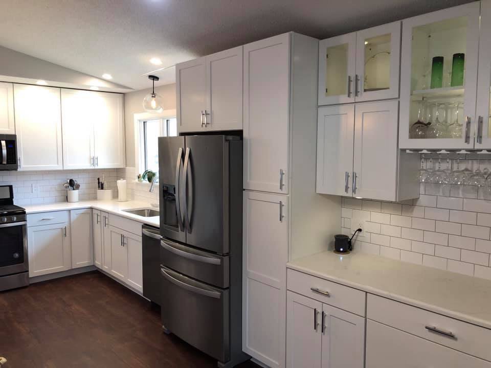 A modern kitchen remodel with white shaker cabinets, subway tile backsplash, and stainless steel appliances by Pro Remodel LLC in St. Charles, MO.