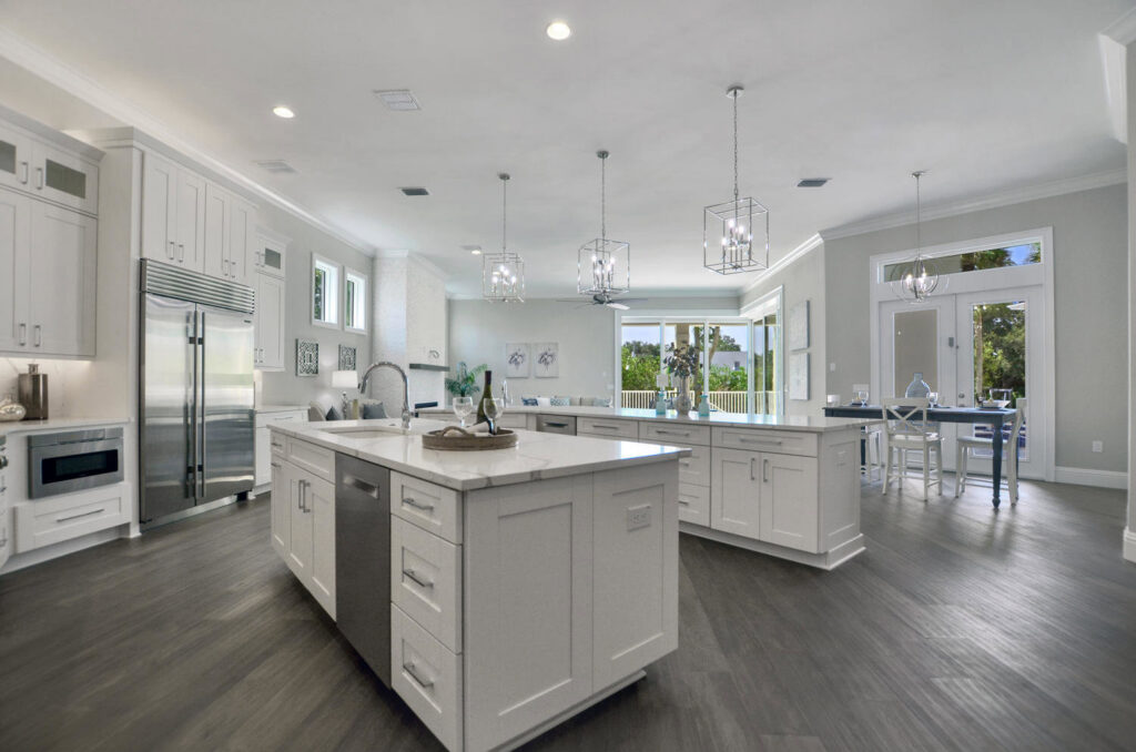 A spacious modern kitchen featuring double islands, white cabinetry, and stainless steel appliances by TamLin Homes Inc in Tampa, FL