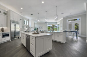 A spacious modern kitchen featuring double islands, white cabinetry, and stainless steel appliances by TamLin Homes Inc in Tampa, FL