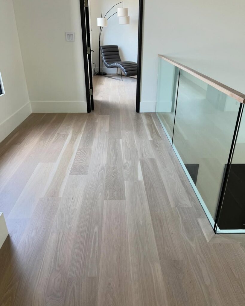 Modern light wood flooring and glass railing installation by Santizo Flooring & Painting in Raleigh, NC.