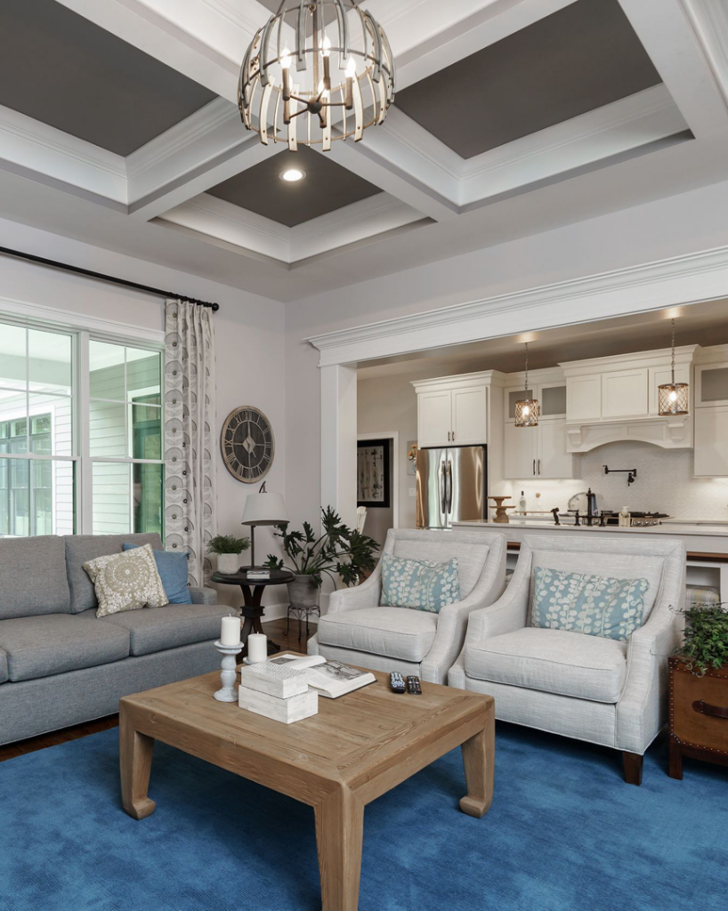 A modern living room with a stylish coffered ceiling and open-concept kitchen by Charlew Builders in Schenectady, NY.