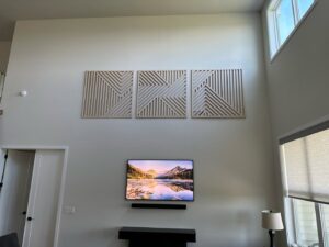 A modern living room with high ceilings, a mounted TV, and decorative wall panels by Imagine It Home Improvements Co. in Bethlehem, PA.