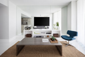 A modern living room interior with a large television, sleek console, and contemporary furniture, remodeled by JNY Remodeling INC in Fort Lauderdale, FL.