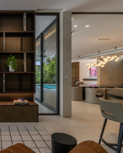 Modern living room renovation featuring custom built-ins and large glass doors by J Romano Group in Miami Beach, FL