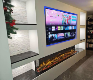 Modern media wall with large mounted TV and electric fireplace installed by SMB Construction in Toledo, OH.