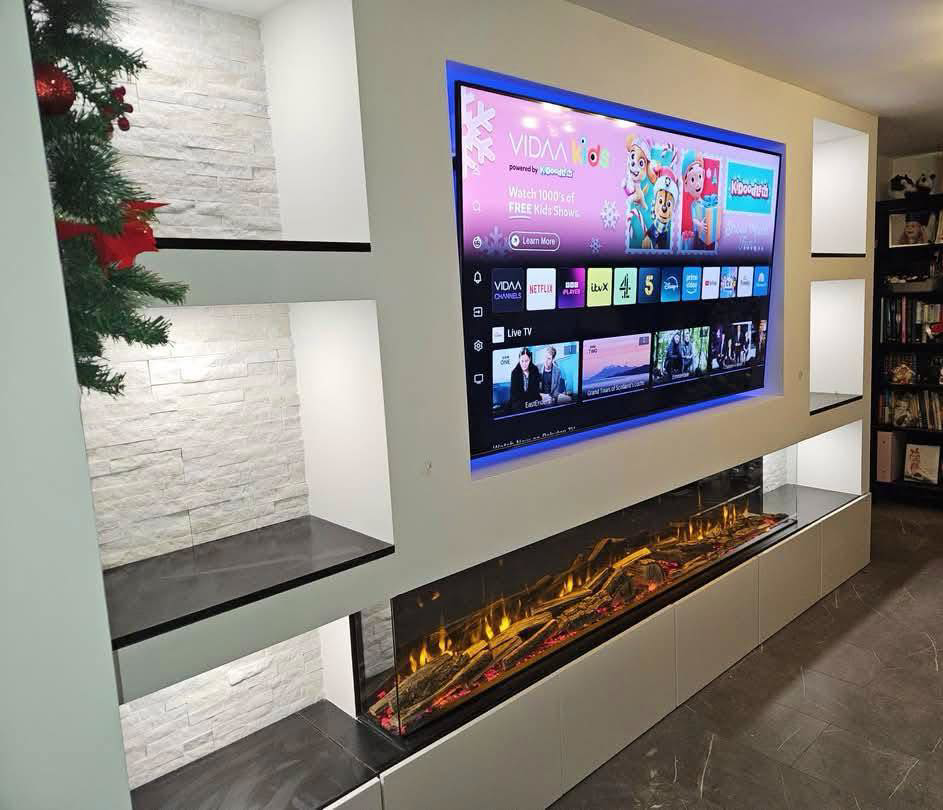 Modern media wall with large mounted TV and electric fireplace installed by SMB Construction in Toledo, OH.