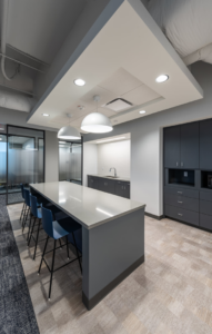 A modern office breakroom and kitchenette with an island and cabinets, a commercial project by Drash Contracting Company LLC in San Antonio, TX.