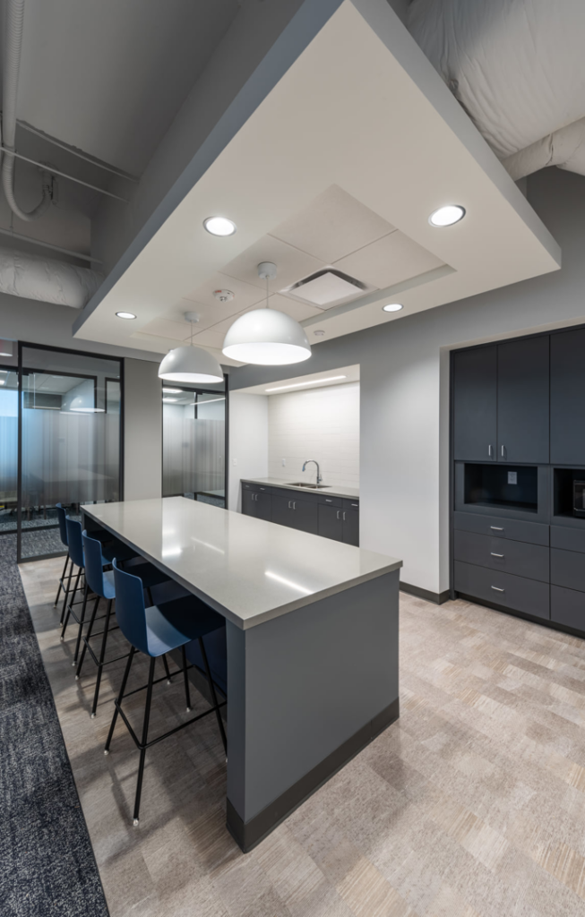 A modern office breakroom and kitchenette with an island and cabinets, a commercial project by Drash Contracting Company LLC in San Antonio, TX.