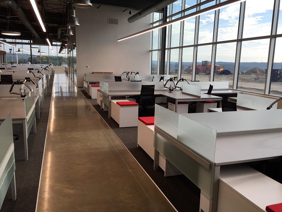 A modern office space with polished concrete floors and white desks by Heavy Duty Floors, LLC in New Britain, CT.