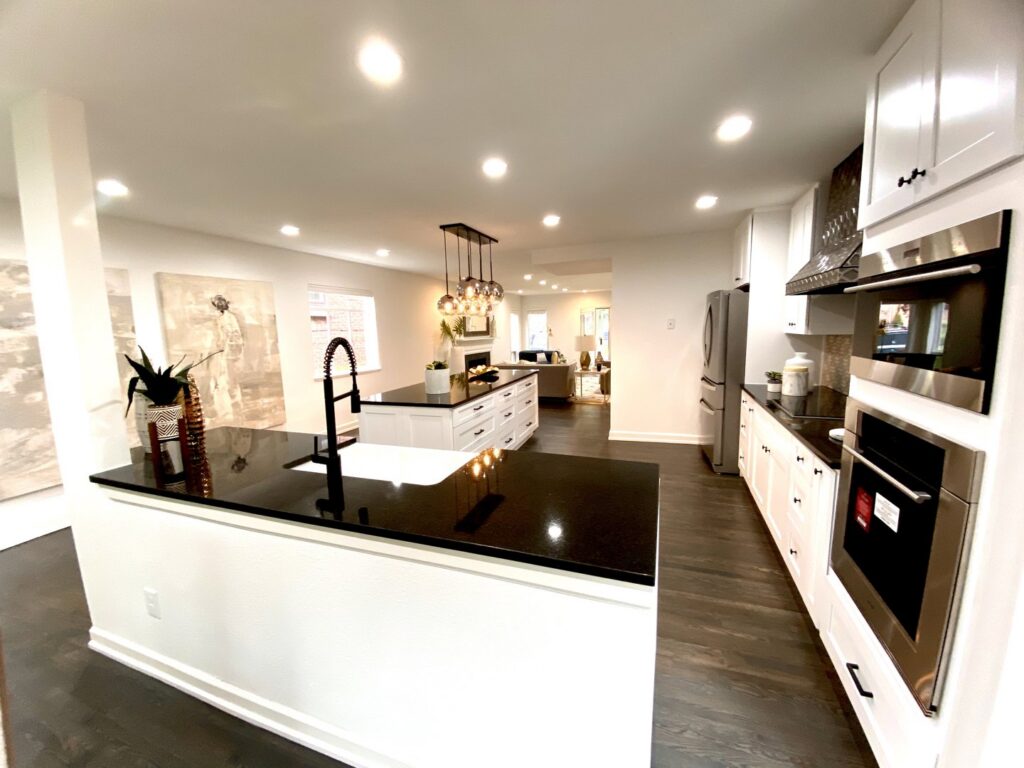A modern open-concept kitchen with new cabinets, appliances, and an island, completed by Infinite Creations Construction, LLC in Denver, CO