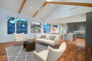 A spacious modern open-concept living room and kitchen with vaulted ceilings by Transformations Custom Build in Austin, TX