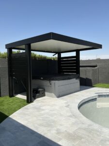 A modern outdoor structure providing sun protection over a hot tub next to a pool, installed by Phoenix Rain Gutters and Sun Protection in Glendale, AZ.