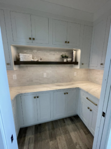 A modern pantry with white cabinets, marble countertops, and subway tile backsplash by Abbott Construction LLC in Boxford, MA.