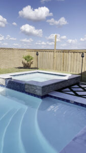 A modern pool and spa design with intricate tiling and clean lines by Limitless Custom Pools and Backyards in Houston, TX.