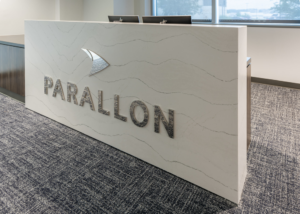 A modern reception desk in a commercial interior space, showcasing a completed project by Drash Contracting Company LLC in San Antonio, TX.