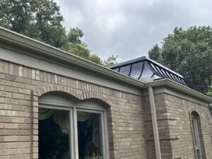 A brick house showcasing a modern black roof feature or skylight installed by Music City Exteriors in Nashville, TN