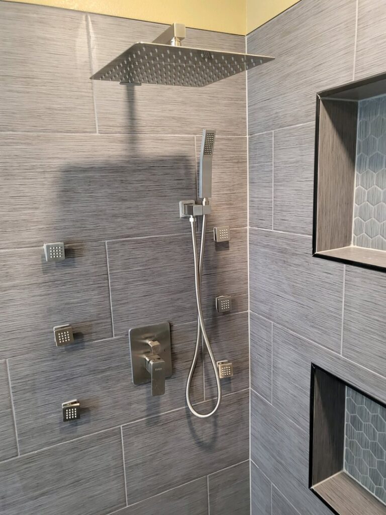 A newly installed modern shower system with multiple body jets and a rain showerhead by Mr. Affordable LLC in Denver, CO.