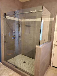 A modern shower with sleek sliding glass doors installed by Southwest Restoration & Design, Inc. in Peoria, AZ.