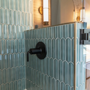 A close-up of modern blue-green shower tile installation by Rockin' Remodeling LLC in Austin, TX